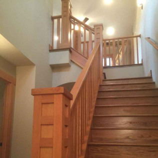 Wooden staircase with Craftsman-style banisters and posts in a home.