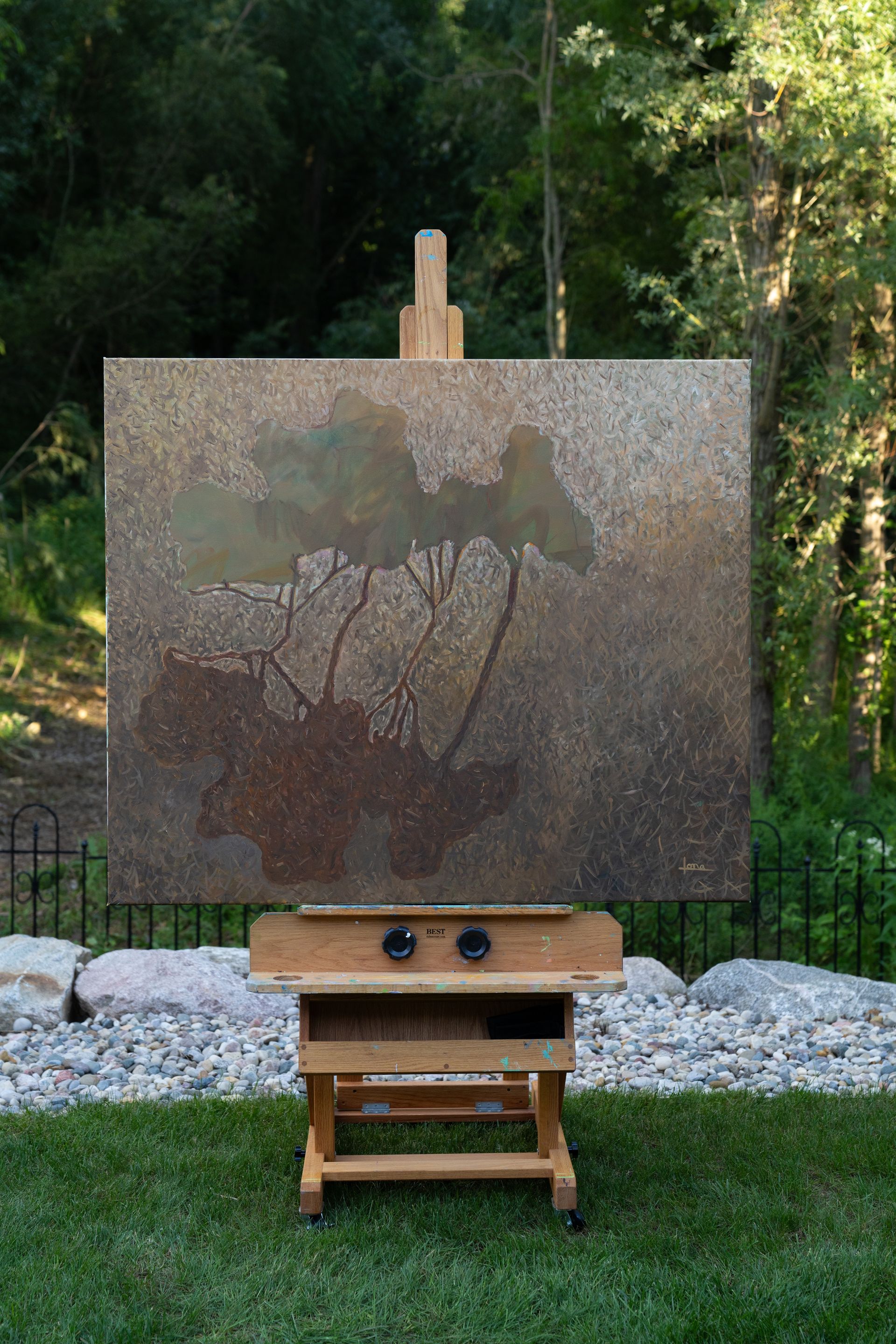 Painting on easel in outdoor setting; muted tones, possibly water lilies.