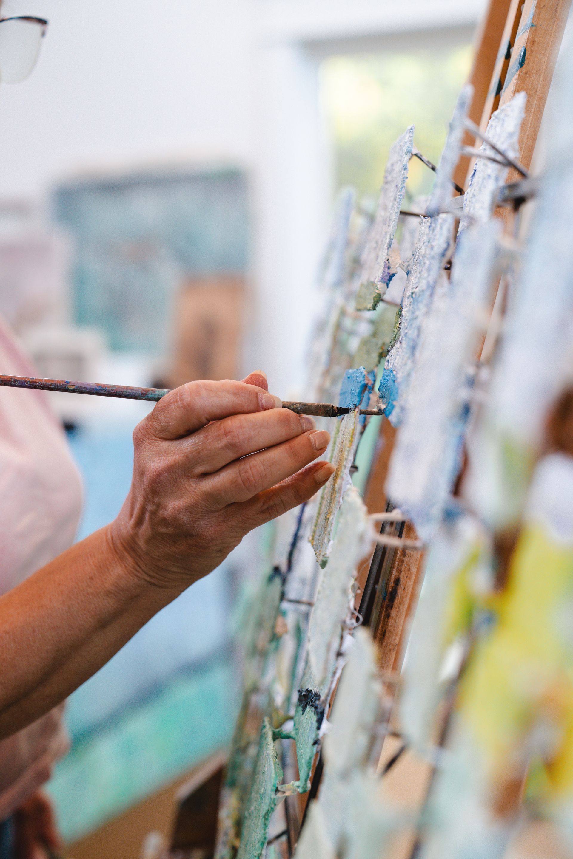 Person overlooking a dark lake, with a snow-capped mountain backdrop and green grassy landscape.