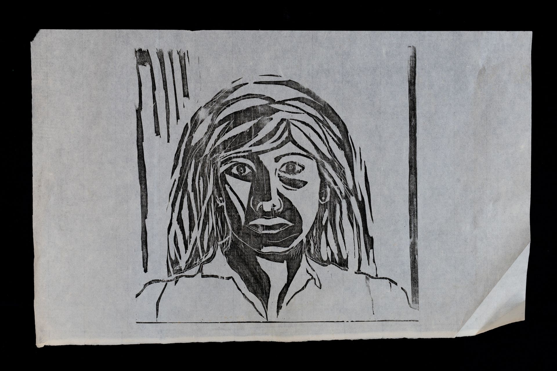 Linocut portrait of a person with wide eyes, looking forward, in a square frame.