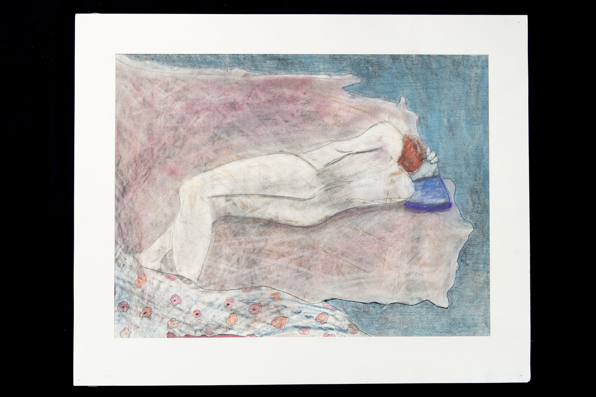 Person in white suit reclining on pink and blue surface.