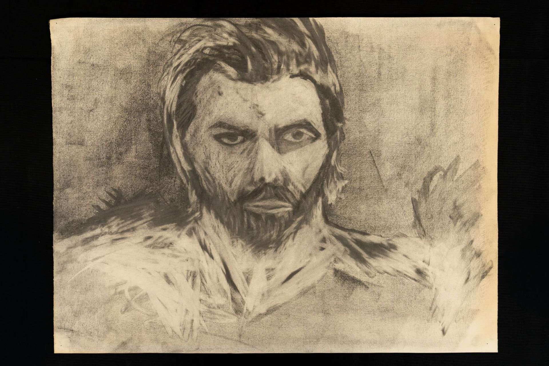 Charcoal portrait of a man with beard and focused expression.