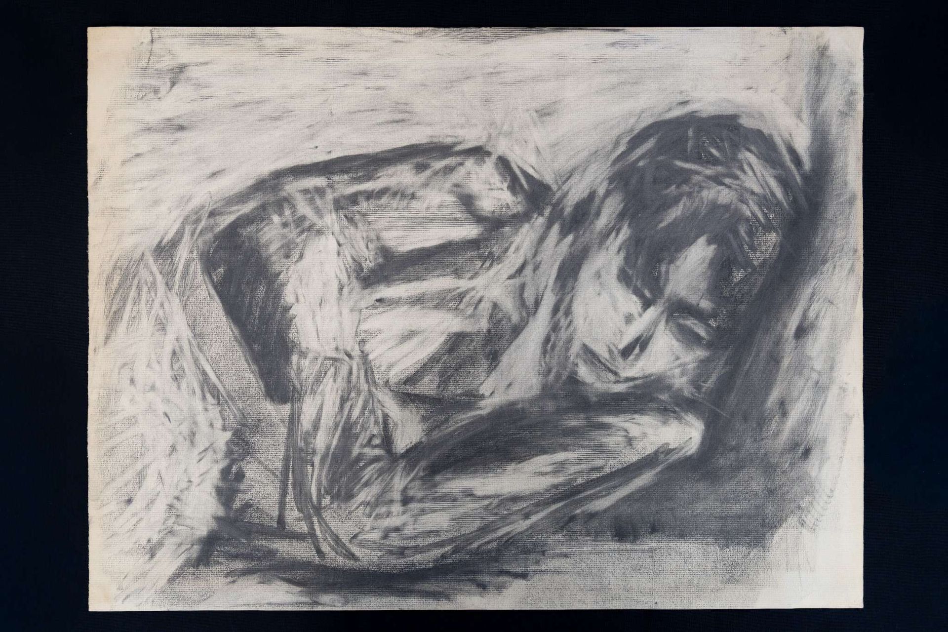 Charcoal drawing of a person curled up, head resting on arms. Soft, blurred lines, dark shading.