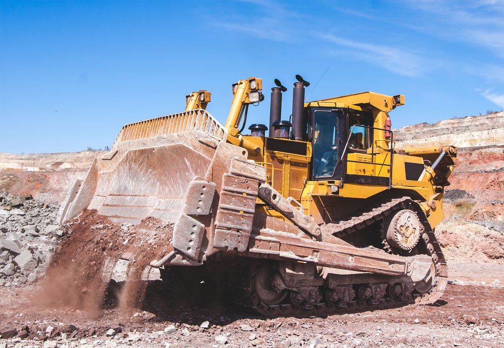 A Bulldozer is Moving Dirt in a Dirt Field — Keppel Coast Diesel In Maryvale, QLD