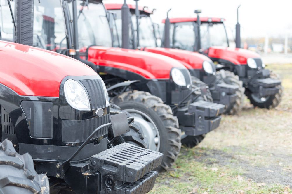 A Row Of Red And Black Tractors Parked In A Field — Keppel Coast Diesel In Maryvale, QLD