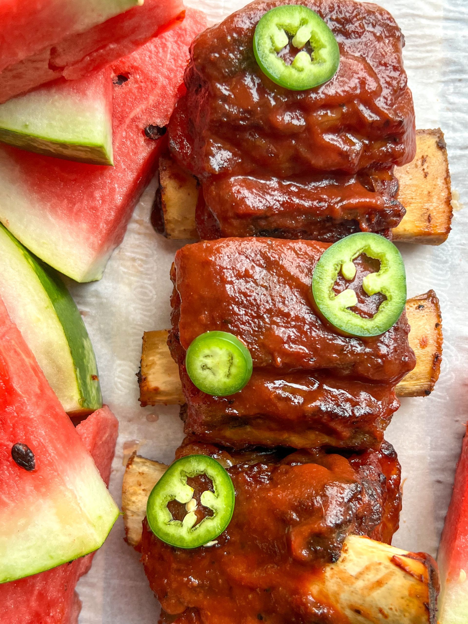 A close up of a plate of food with watermelon and jalapenos.