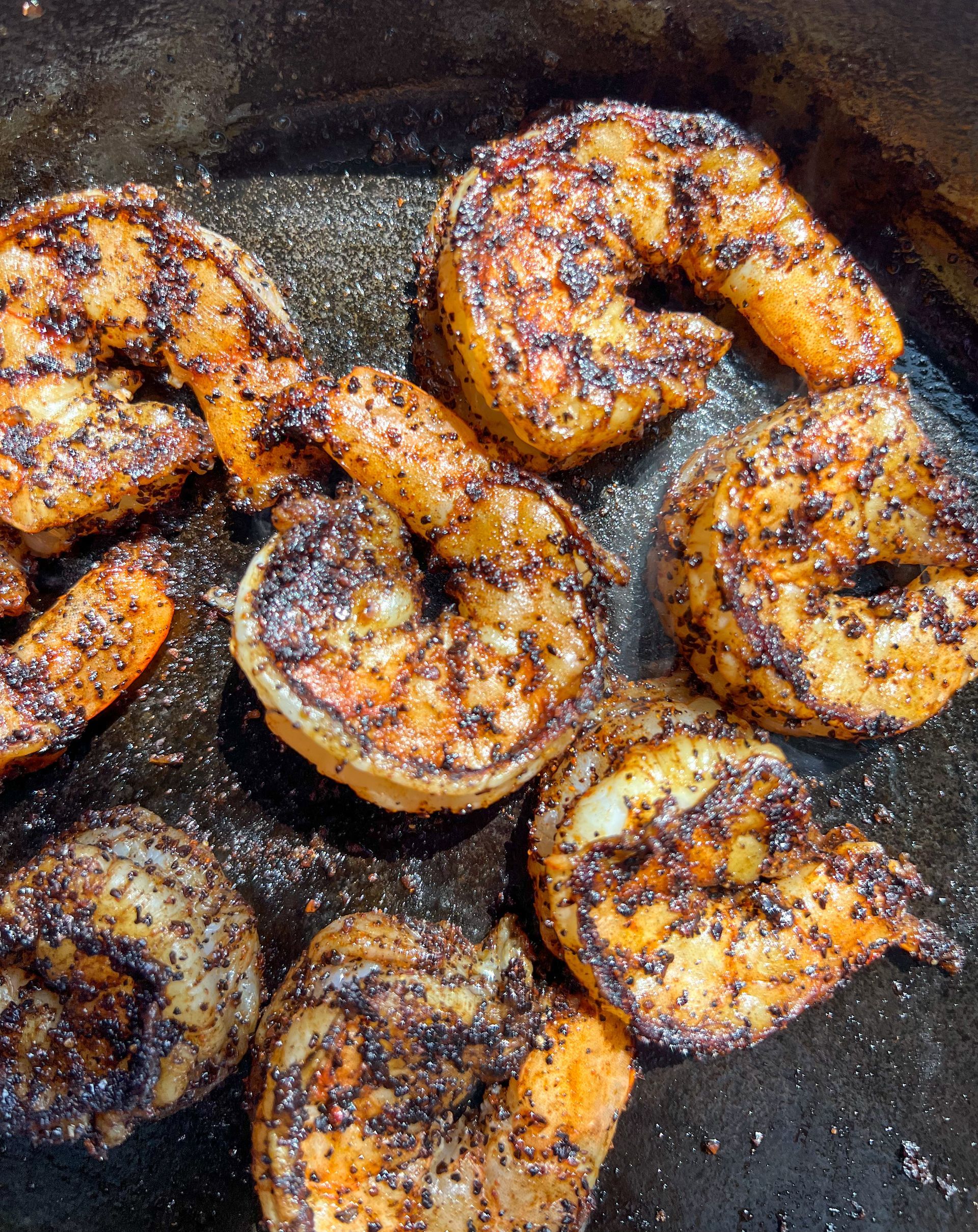 Shrimp are being cooked in a frying pan