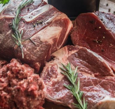 A pile of raw meat and ground beef on a table.