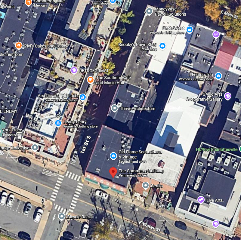 A large brick house with a red awning over the front door.