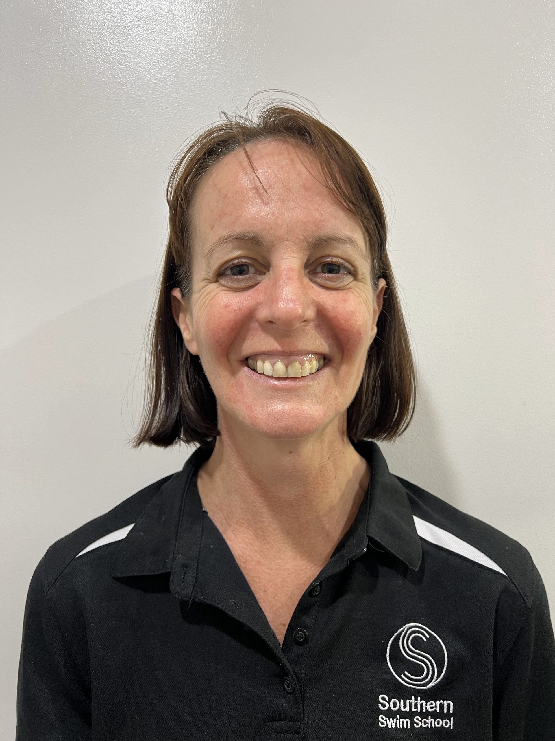 A woman in a black shirt is smiling for the camera.