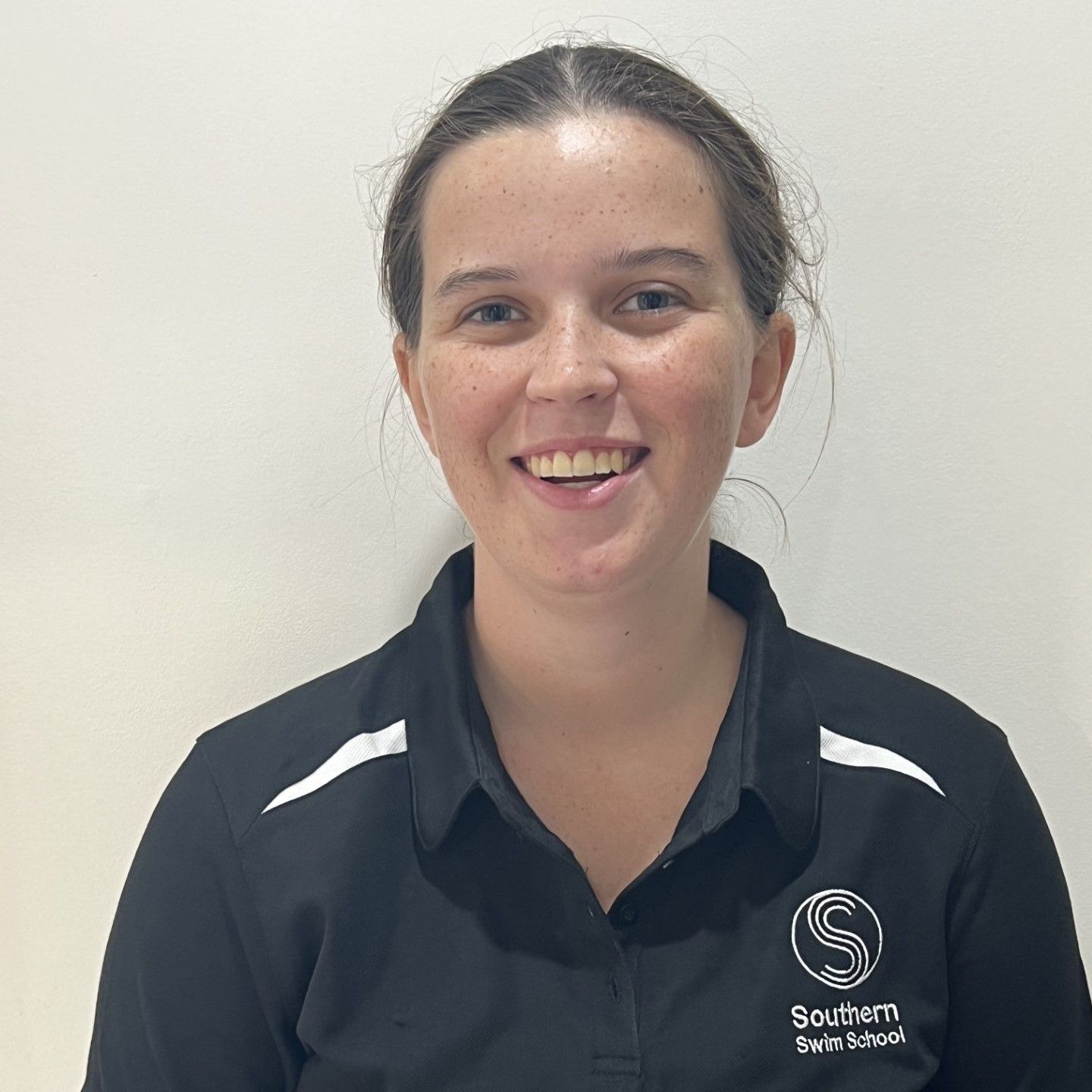 A woman in a black shirt is smiling for the camera.