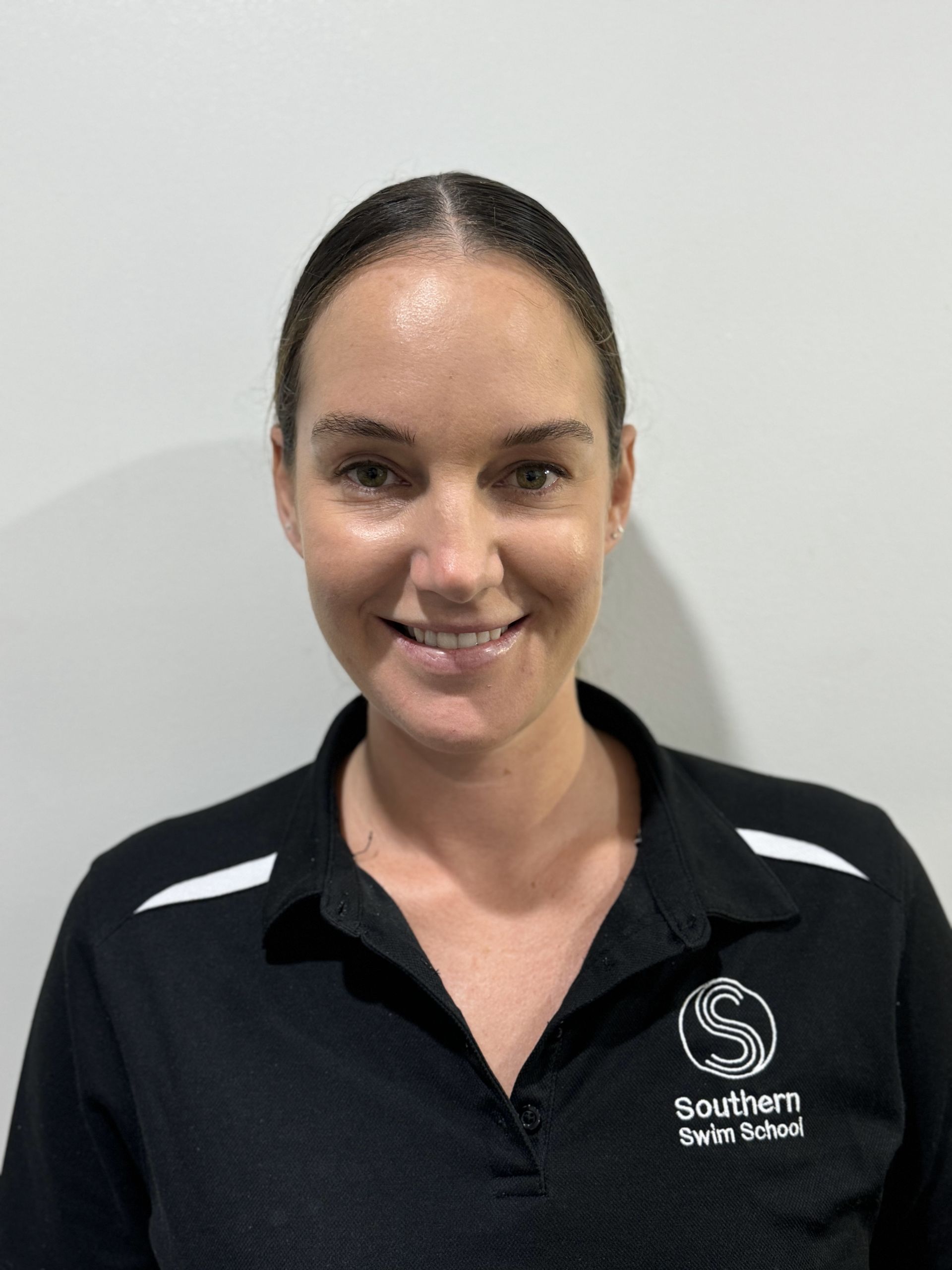 A woman in a black shirt is smiling for the camera.