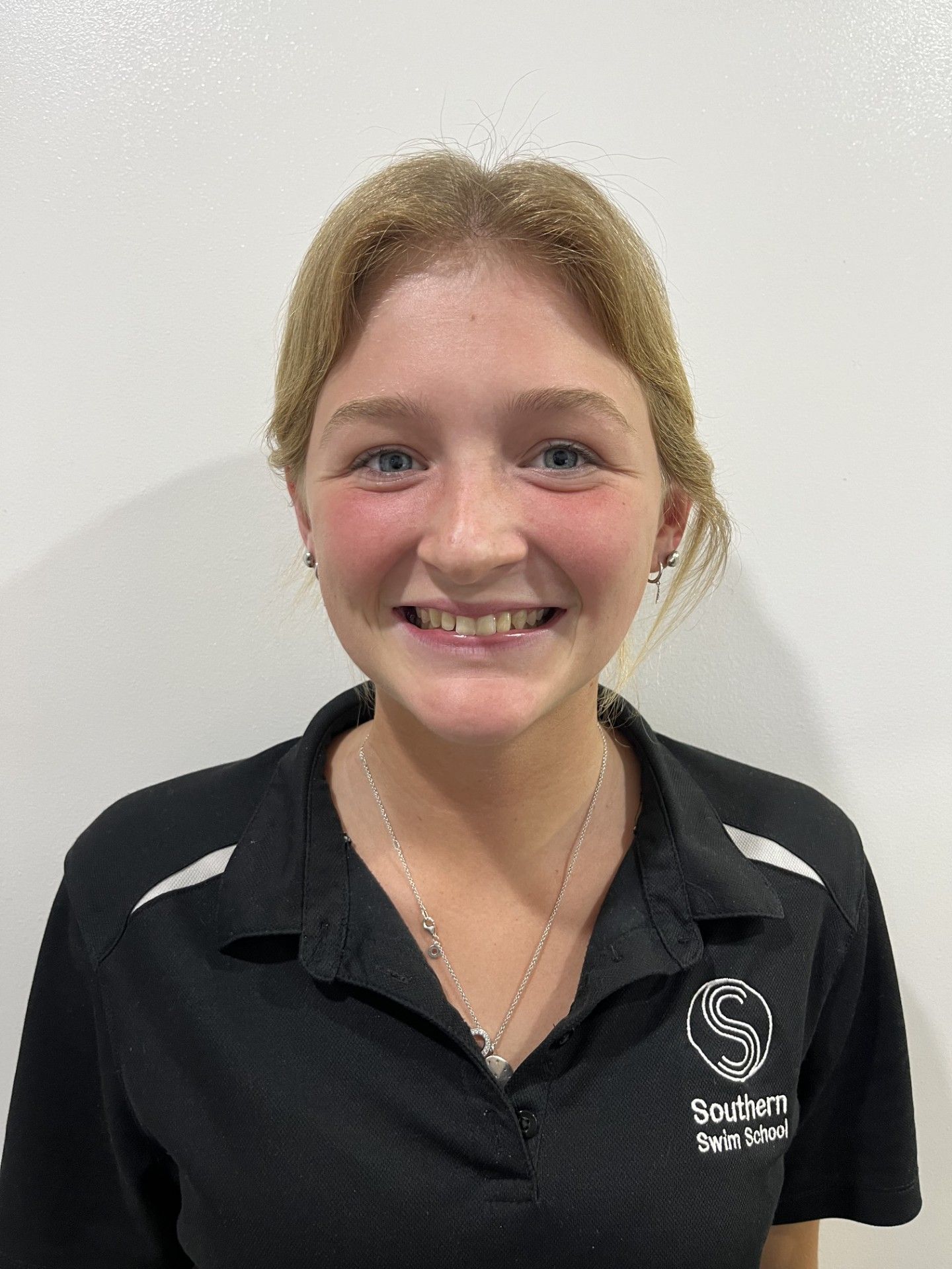 A young woman wearing a black shirt is smiling for the camera.