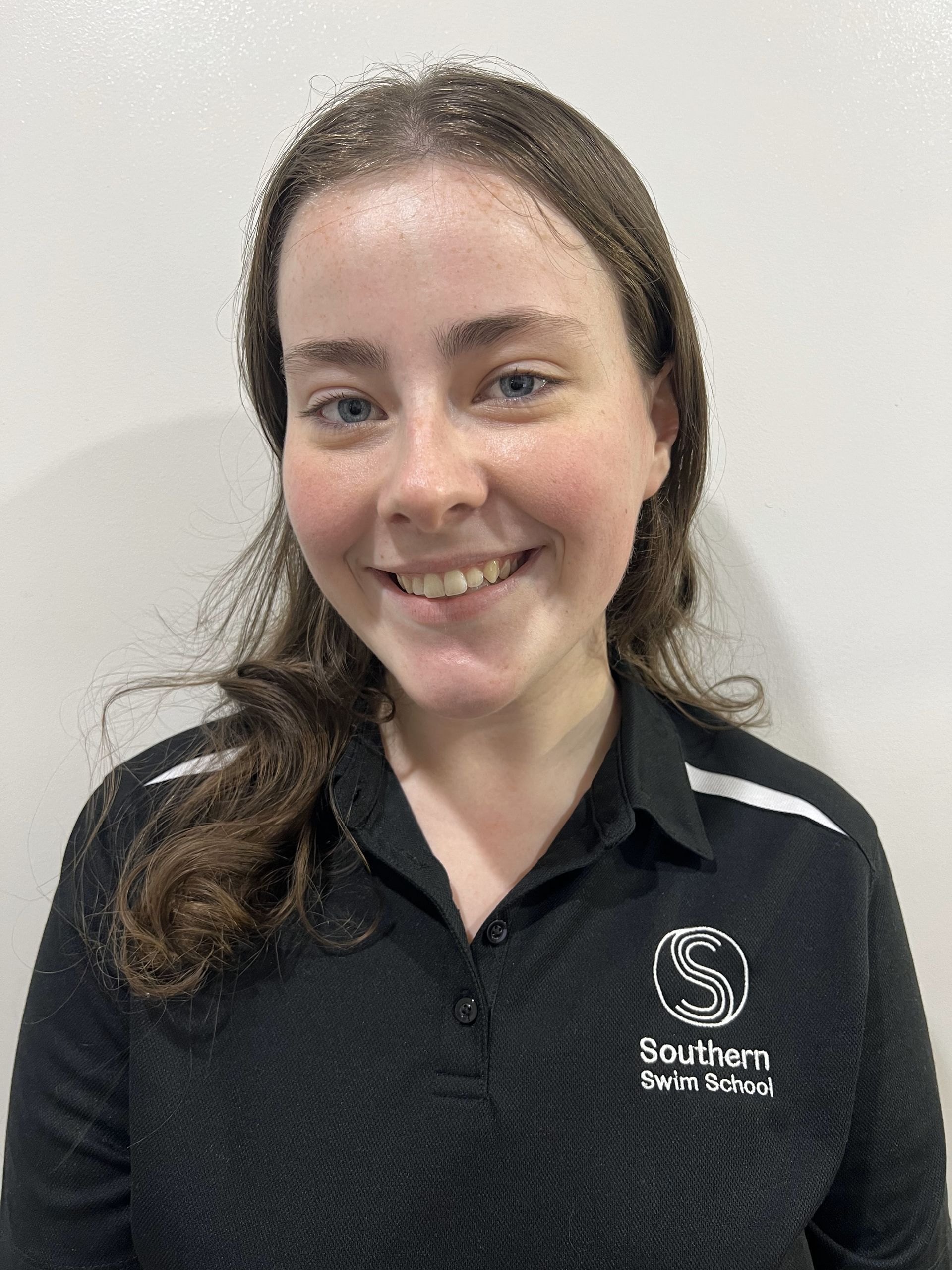 A young woman wearing a black shirt is smiling for the camera.