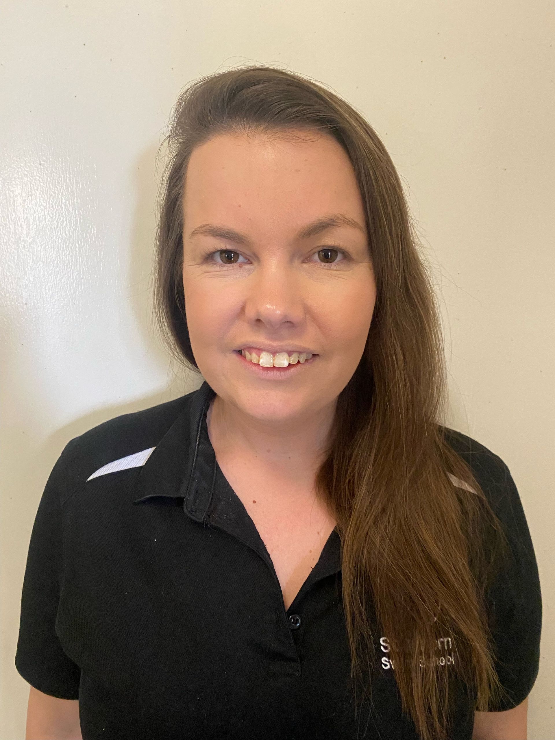 A woman in a black shirt is smiling for the camera.