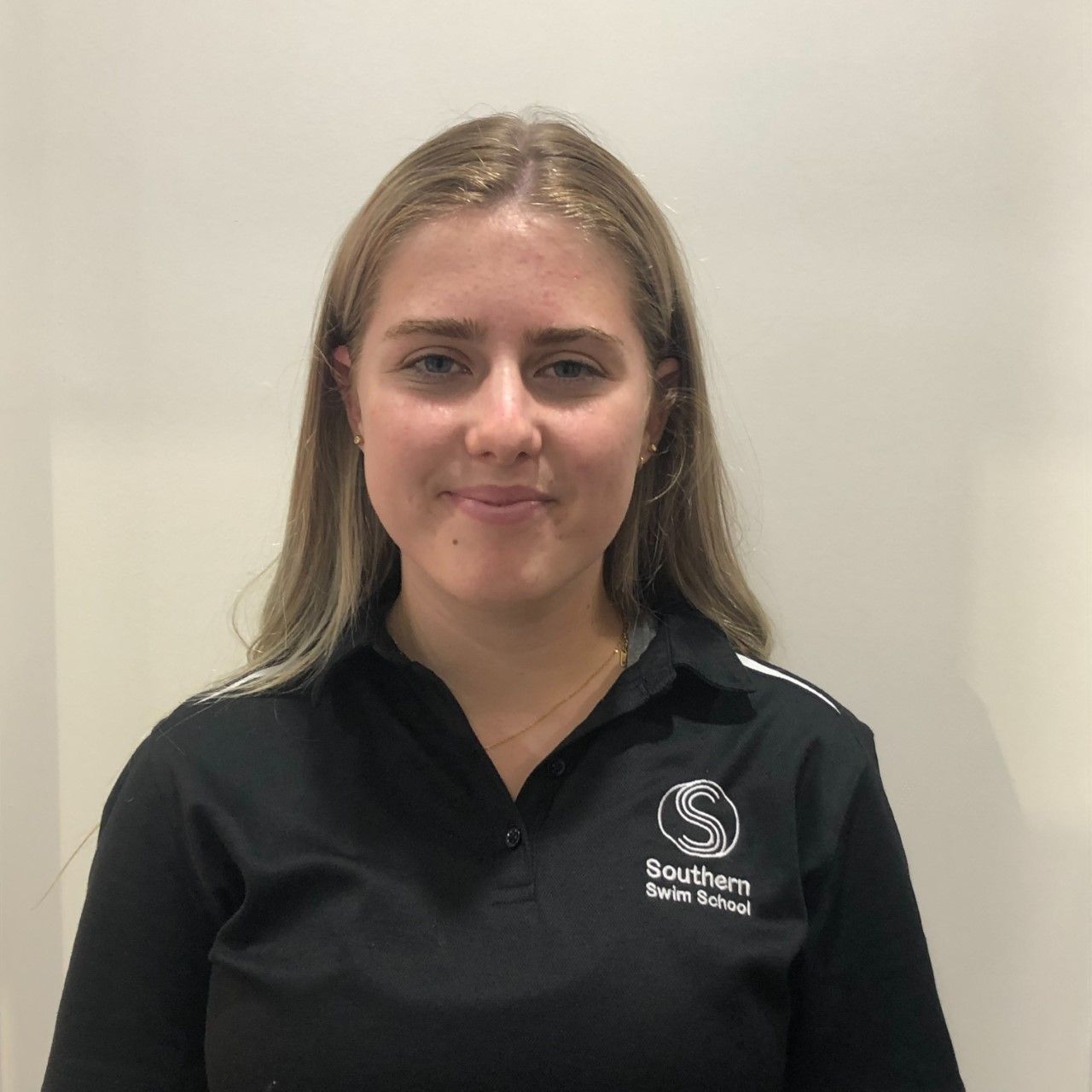 A young woman wearing a black shirt with the letter s on it