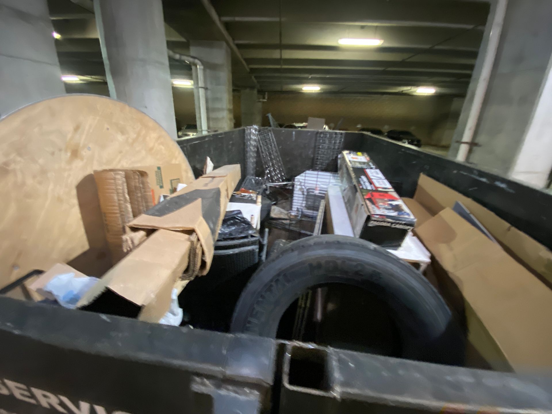 A dumpster filled with various items including a tire