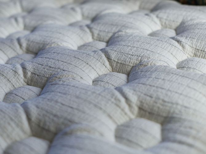 A close up of a white mattress on a bed.