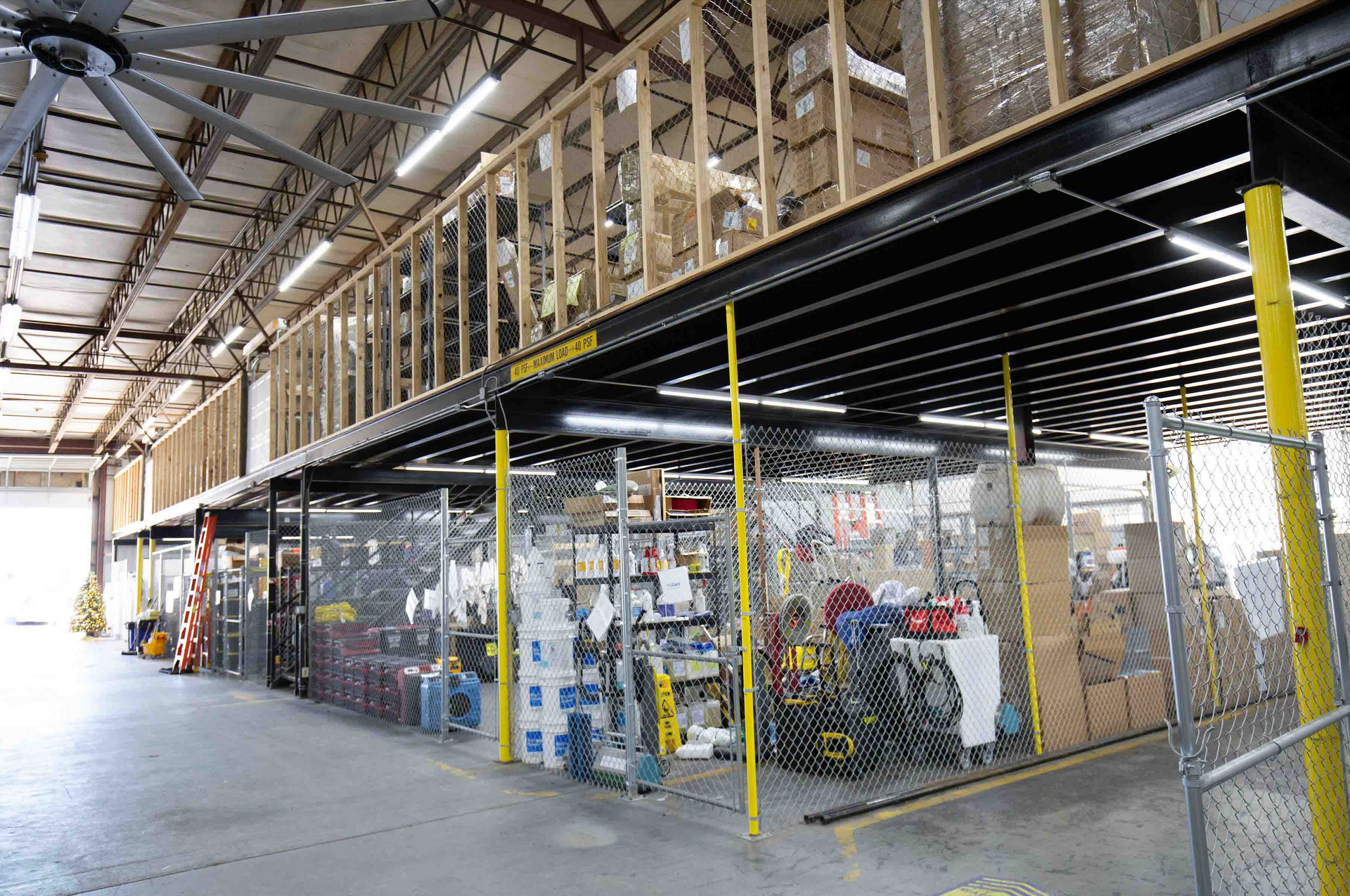 Outdoor patio with light gray couches, white pergola, blue-trimmed windows, and stone floor.