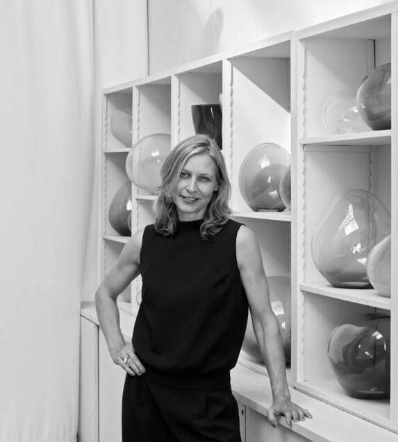 Simone Lülling steht vor einem Regal voller Vasen.