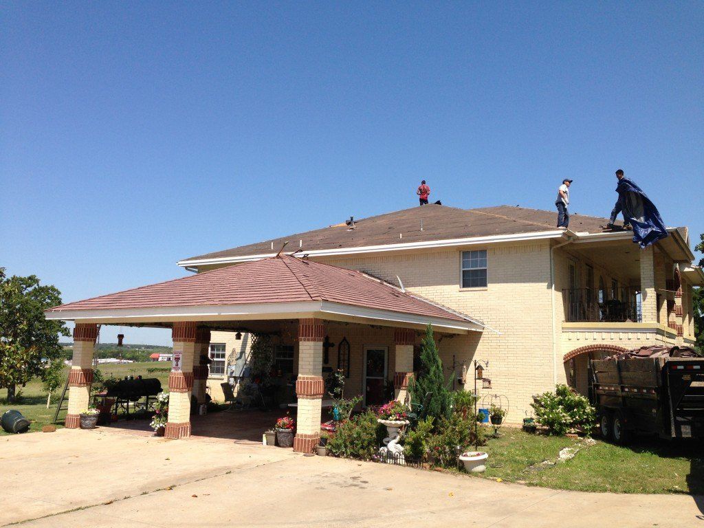 two men are working on the roof of a house