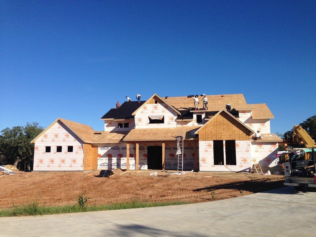 a house that is being built with a roof that is covered in a roofing material