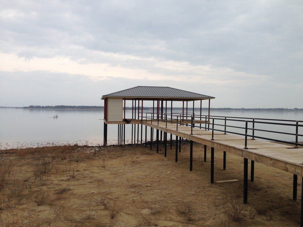 a large body of water with a dock in the foreground