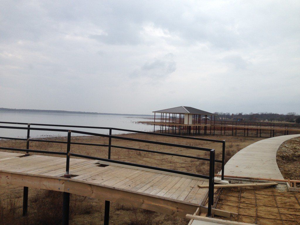 a wooden walkway leading to a gazebo overlooking a lake