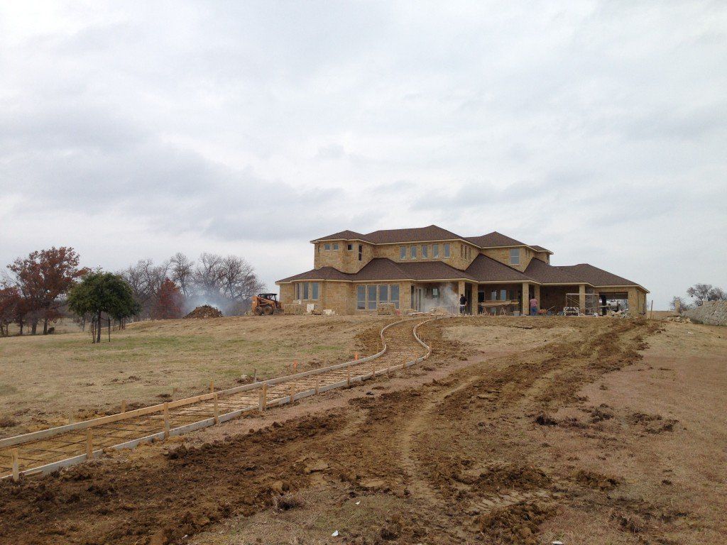 a large house is being built in the middle of a dirt field