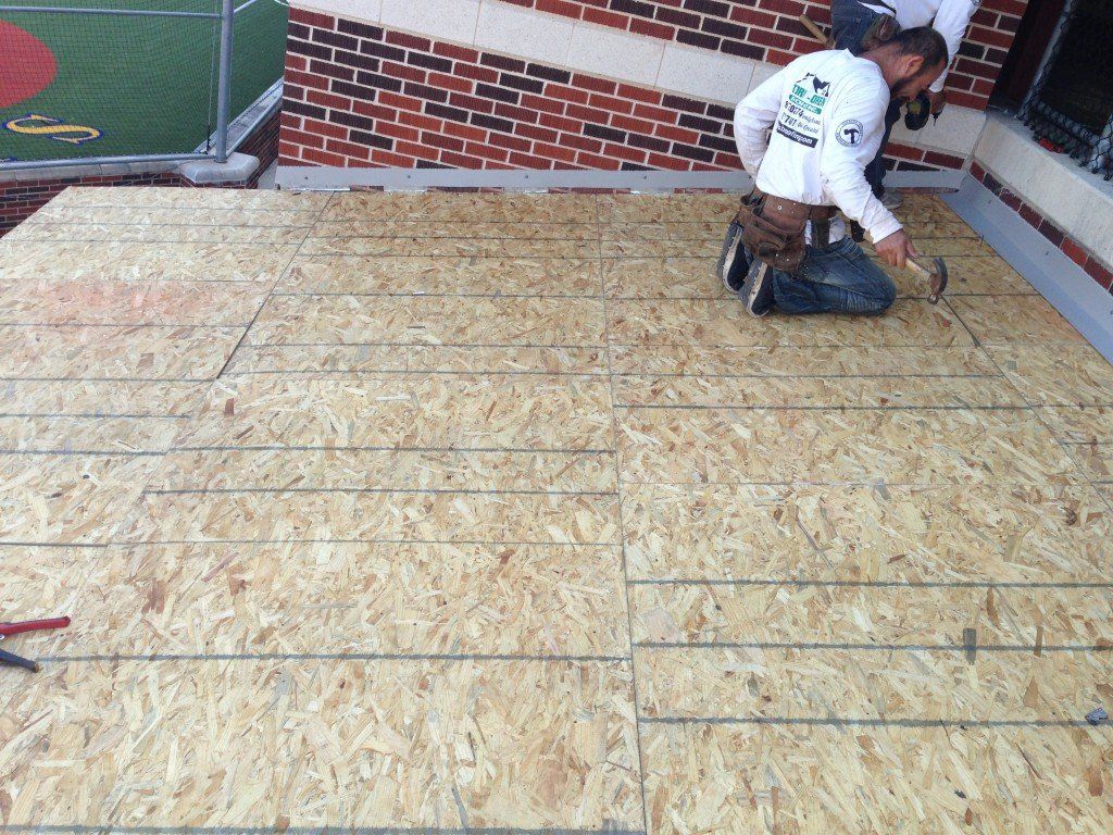 a man wearing a shirt that says ' roofing ' on it