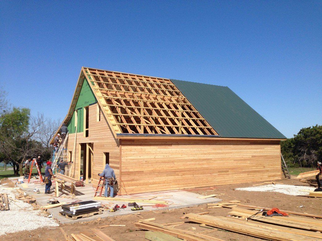 a large wooden house is being built with a green roof