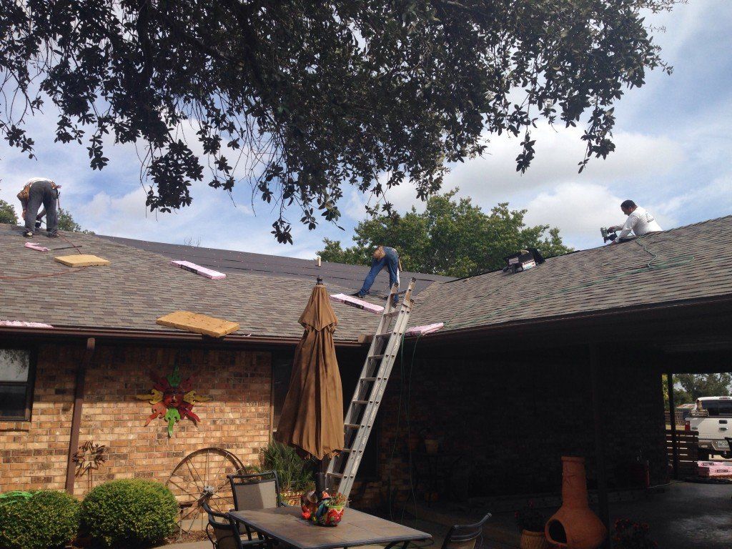 a man on a ladder works on the roof of a house