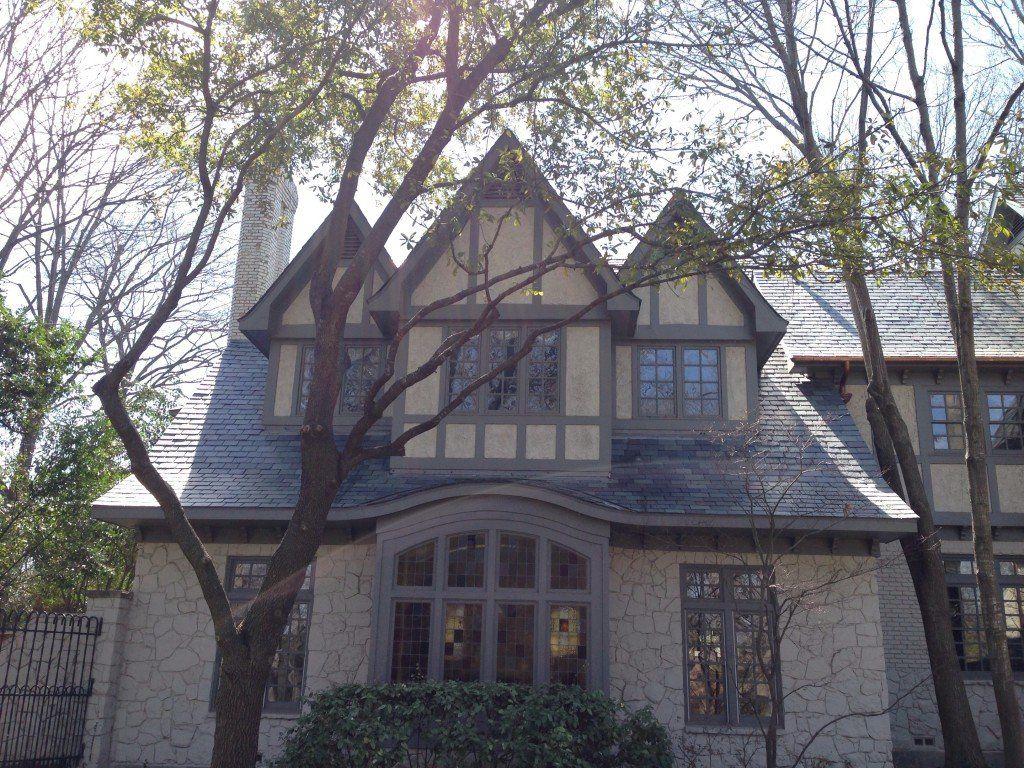 a large house with a slate roof and a tree in front of it