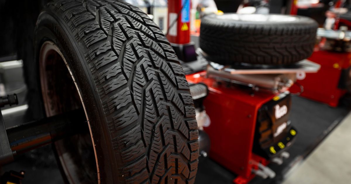 A car tire mounted on a balancing machine in an auto repair shop.