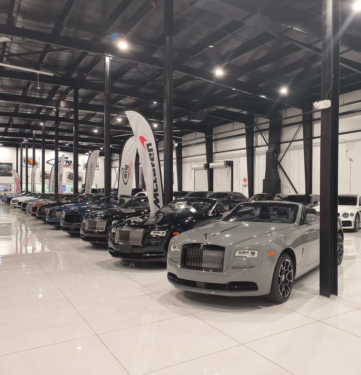 A black car with the doors open is parked in front of a building