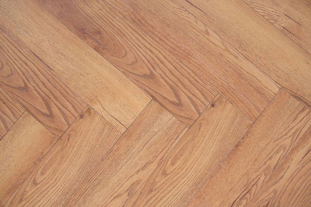 A close up of a wooden floor with a diagonal pattern.