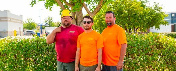 A yellow excavator is breaking rocks on a construction site.
