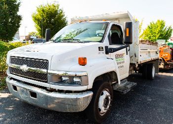 A white dump truck is parked in a parking lot.