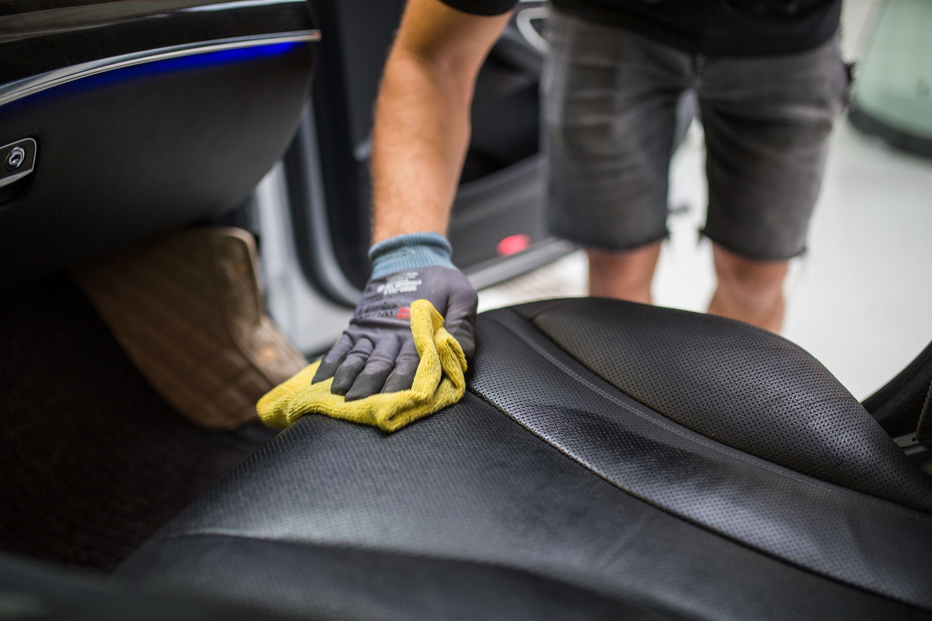 A person is cleaning the seats of a car with a cloth.