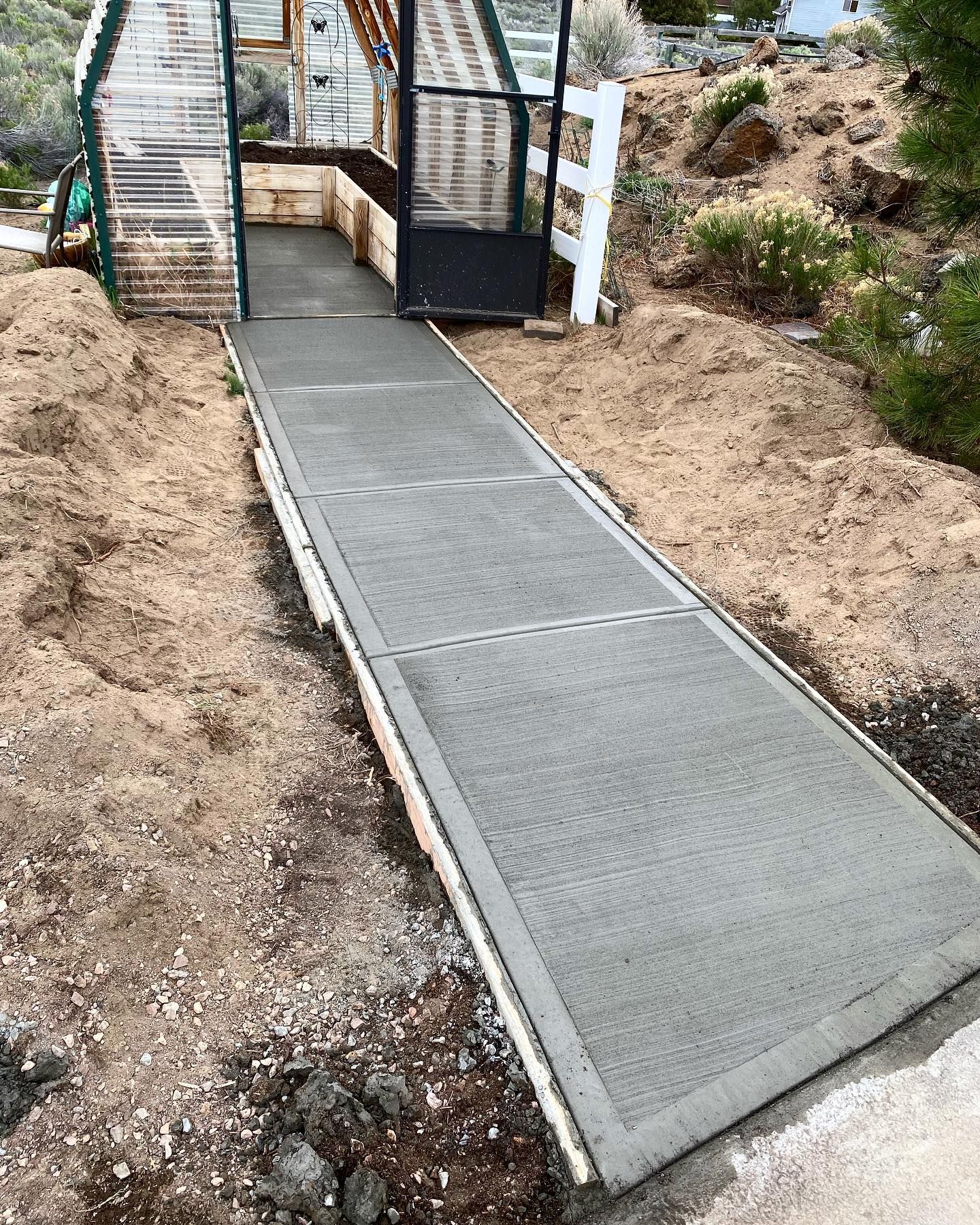 A ramp leading to a greenhouse is being built.