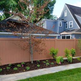 Fence Surrounds A Lush Green Yard — Warren, MI — Kimberly Fence & Supply