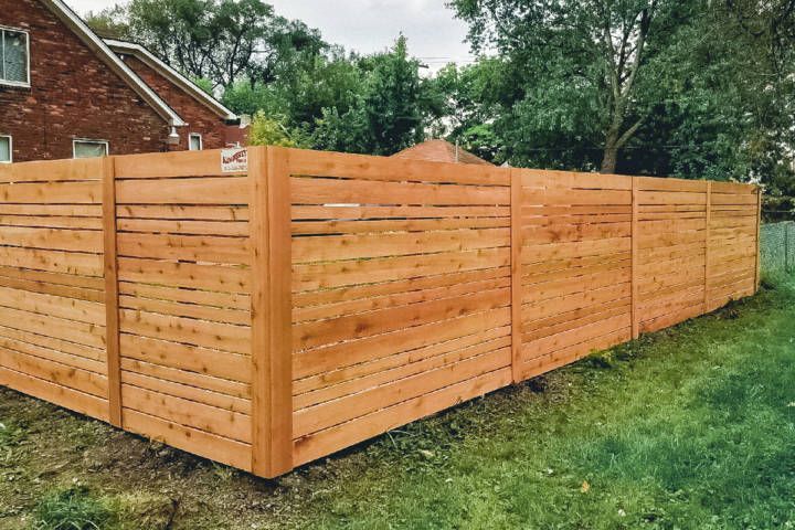 Fence Sitting In The Grass In Front Of A House — Warren, MI — Kimberly Fence & Supply