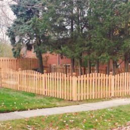 Picket Fence Surrounds A Lush Green Yard — Warren, MI — Kimberly Fence & Supply
