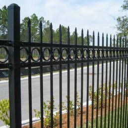 Black Wrought Iron Fence Sitting Next To A Road — Warren, MI — Kimberly Fence & Supply