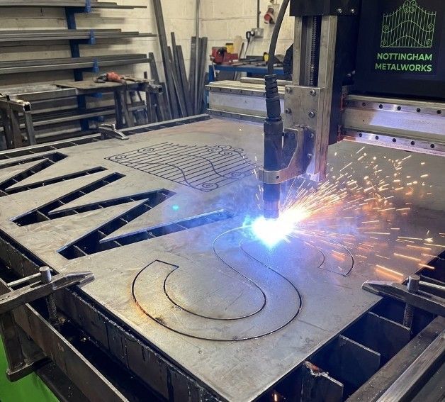 CNC plasma cutting machine fabricating custom metal sign letters in Nottingham workshop