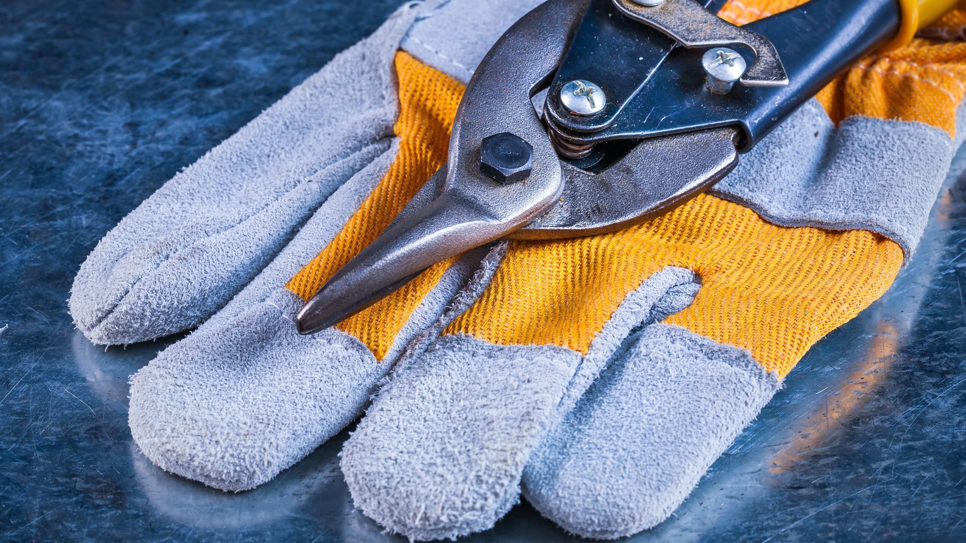 A pair of gloves with a pair of scissors on top of them.