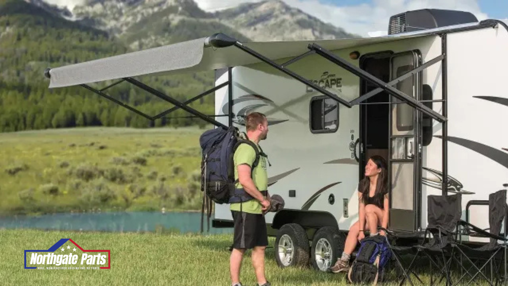 A man and a woman are standing in front of a rv with an awning.