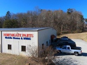 RV storage facility with covered spaces and RVs parked outside on gravel.