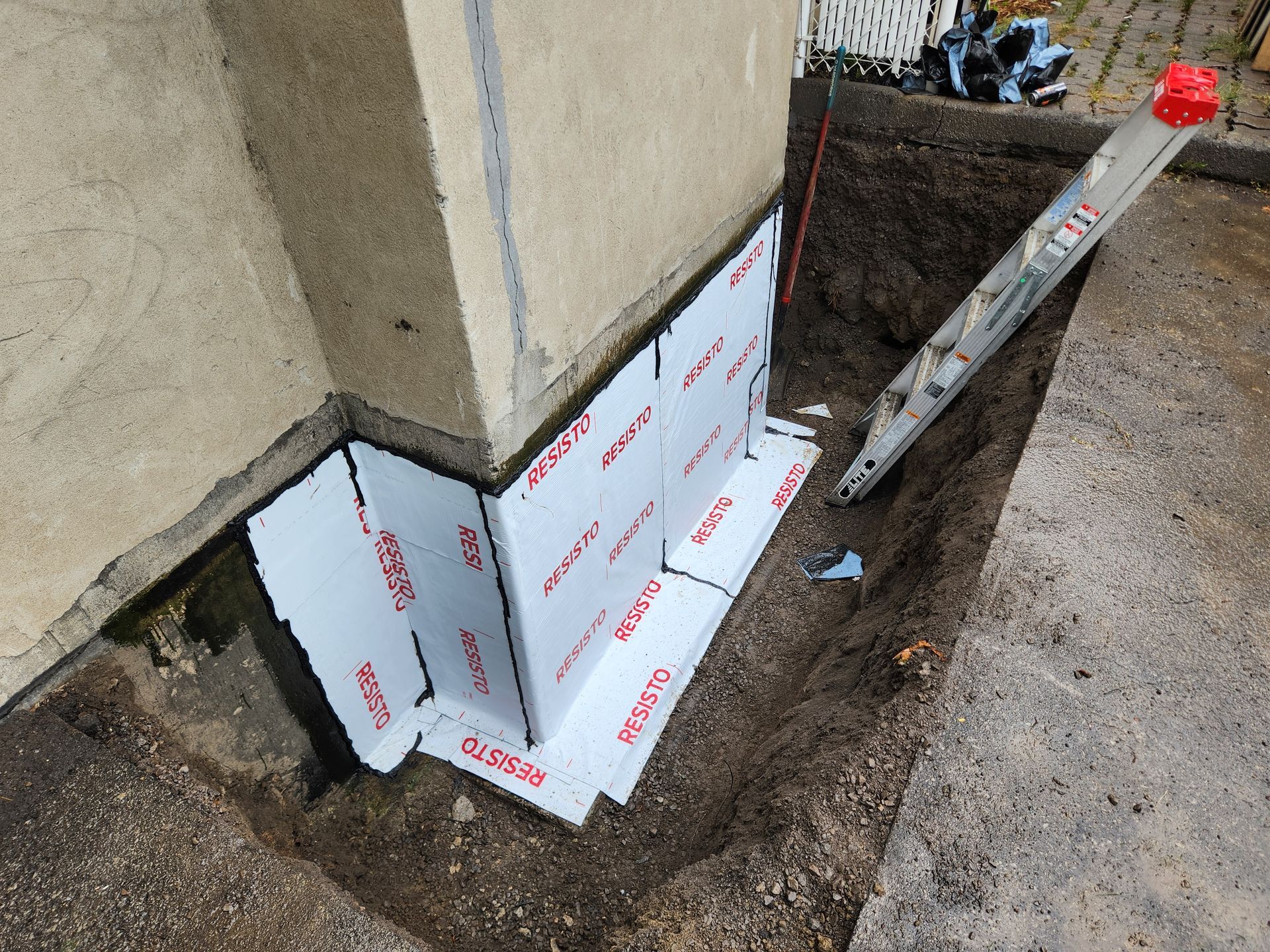Une échelle est assise dans un trou à côté d'un mur.