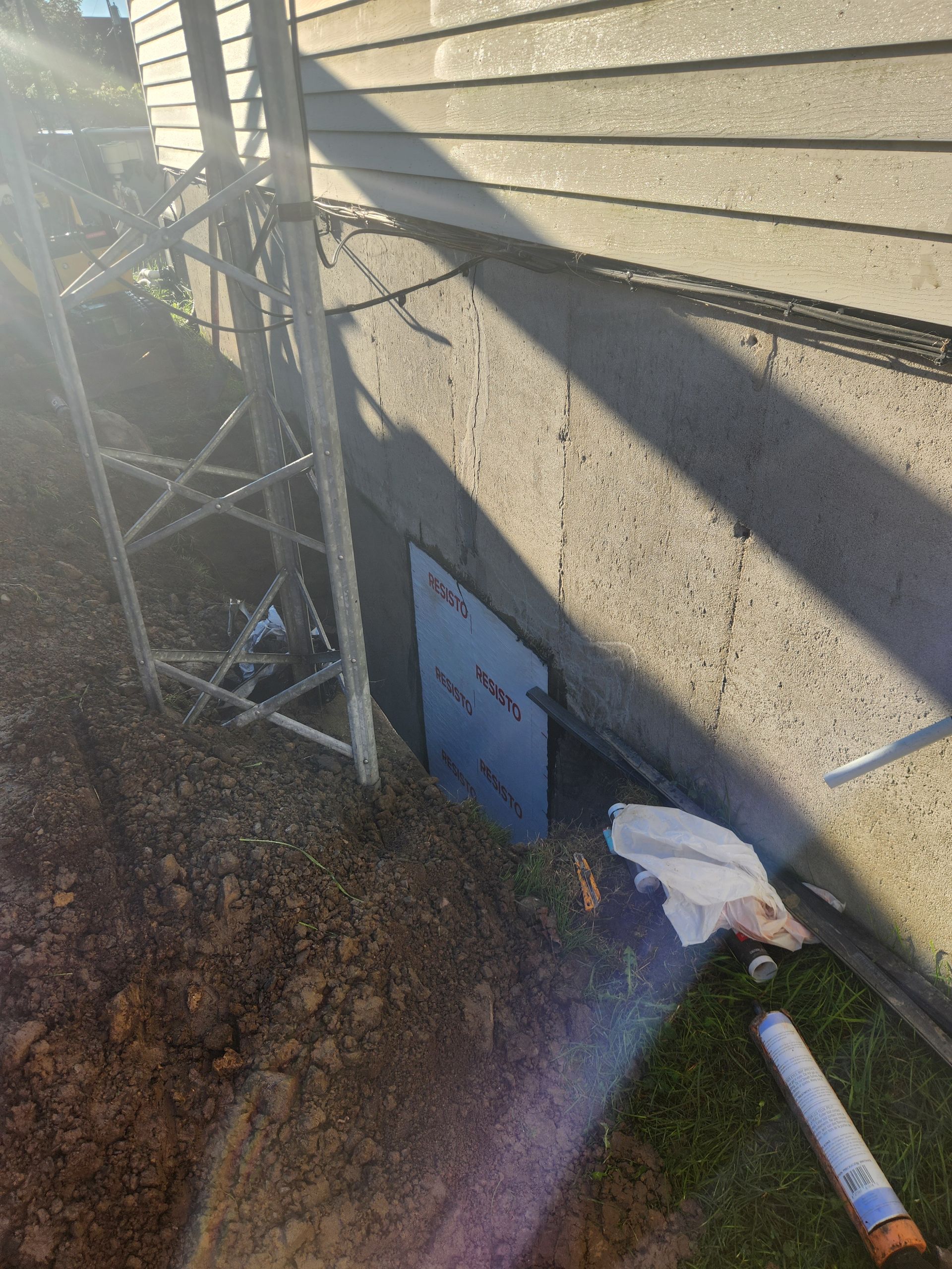 Une personne creuse un trou dans le sol à côté d'une maison.